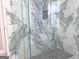 Luxurious glass shower with designer marble style tiles and a mosaic tile floor at 3189 Jackson, Hapeville, GA 30354