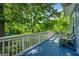 Relaxing covered deck showcases peaceful view and classic furniture with a painted wood floor and ceiling fan at 7550 Fielder Rd, Jonesboro, GA 30236
