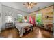 Cozy bedroom featuring hardwood floors, natural light, and a unique decorative cabinet at 7550 Fielder Rd, Jonesboro, GA 30236