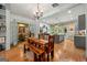 Open dining room featuring wood floors, chandelier and view into the kitchen area at 7550 Fielder Rd, Jonesboro, GA 30236