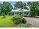 Charming blue home with a covered porch, lush landscaping, and a welcoming gravel driveway at 7550 Fielder Rd, Jonesboro, GA 30236
