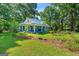Charming blue home featuring a metal roof, a cozy front porch, and a beautiful landscaped front yard at 7550 Fielder Rd, Jonesboro, GA 30236