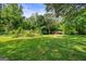 Expansive green yard with mature trees and a rustic shed in the background at 7550 Fielder Rd, Jonesboro, GA 30236