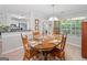 Bright dining room with wood floors and a large window, featuring a wooden table set for four at 1152 Strath Clyde Way, Mcdonough, GA 30253