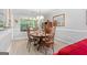 Inviting dining room featuring a round wooden table set for four, bathed in natural light from large window at 1152 Strath Clyde Way, Mcdonough, GA 30253