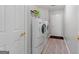 Well-lit laundry room featuring a side-by-side washer and dryer with shelf storage at 1152 Strath Clyde Way, Mcdonough, GA 30253