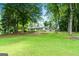 Scenic view of a home's landscaped backyard with lots of mature trees and lush green grass at 312 Flat Shoals Church Rd, Stockbridge, GA 30281