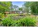 Landscaped backyard featuring an outdoor patio, lush lawn, and a well maintained brick home at 312 Flat Shoals Church Rd, Stockbridge, GA 30281