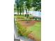 View from a window overlooking a backyard with mature trees, lush landscaping, and a tranquil lake at 312 Flat Shoals Church Rd, Stockbridge, GA 30281