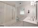 Clean bathroom with a shower, double sink vanity, white cabinetry, neutral tile floors, and a bright window at 312 Flat Shoals Church Rd, Stockbridge, GA 30281