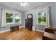 Bright bedroom with hardwood floors, neutral walls, a dresser with mirror, and peaceful outdoor views at 312 Flat Shoals Church Rd, Stockbridge, GA 30281