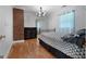 Cozy bedroom featuring hardwood floors, closet with mirror door, modern chandelier, and queen-size bed at 312 Flat Shoals Church Rd, Stockbridge, GA 30281