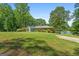 View of the house on a hill with large grassy front yard, leading down to a lake at 312 Flat Shoals Church Rd, Stockbridge, GA 30281