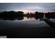 Scenic lake view with sunset, dock, and Christmas tree, creating a serene and inviting atmosphere at 312 Flat Shoals Church Rd, Stockbridge, GA 30281