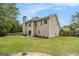 Back view of home showing a spacious, grassy backyard with a patio area and mature trees at 5409 Trumpet Vine Se Trl, Mableton, GA 30126