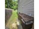 Fenced backyard with green grass and mature trees, next to air conditioner equipment at 590 Dot Dr, Atlanta, GA 30349