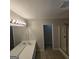 Well-lit bathroom features dual sinks, white cabinets, neutral walls, and a walk-in shower at 590 Dot Dr, Atlanta, GA 30349