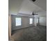 Spacious primary bedroom featuring a ceiling fan, plush carpeting, and plenty of natural light from two windows at 590 Dot Dr, Atlanta, GA 30349