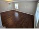 Bright living room featuring hardwood floors and ample natural light from a large window at 590 Dot Dr, Atlanta, GA 30349