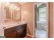 Bathroom features a double vanity, a framed mirror, and a tub adjacent to an open doorway at 145 County Line Ct, Fayetteville, GA 30215