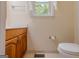 Bright bathroom showcasing a wooden vanity, toilet, and window, offering a comfortable and functional space at 145 County Line Ct, Fayetteville, GA 30215