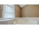 An angled whirlpool tub is adjacent to a window at 145 County Line Ct, Fayetteville, GA 30215