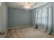 Blue bedroom featuring a fan, beige carpet, and a window with sheer light blue curtains at 145 County Line Ct, Fayetteville, GA 30215