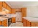 Functional kitchen featuring wood cabinets, an island, white countertops, and appliances, providing a practical cooking space at 145 County Line Ct, Fayetteville, GA 30215