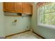 Laundry area equipped with overhead cabinets and a window, providing functionality and natural light at 145 County Line Ct, Fayetteville, GA 30215