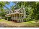 Charming home exterior with a porch and chimney, surrounded by lush greenery at 145 County Line Ct, Fayetteville, GA 30215