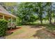 Lush side yard featuring a covered porch and mature trees at 145 County Line Ct, Fayetteville, GA 30215