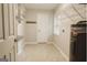 Bright laundry room with shelving, tile flooring, and an efficient water heater at 8394 Banks Mill Rd, Douglasville, GA 30135