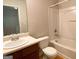 Bright bathroom with a white vanity, toilet, and a tub with a shower at 1843 Grove Way, Hampton, GA 30228