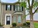 Charming brick townhome featuring black shutters and a well-manicured front yard at 1843 Grove Way, Hampton, GA 30228