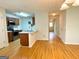 Open-concept kitchen with stainless appliances and hardwood floors extending into dining area at 1843 Grove Way, Hampton, GA 30228