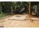 Fully-fenced backyard with a fire pit, gravel landscaping, and an outdoor dining area at 228 Hunt Club Cir, Temple, GA 30179