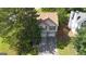 An aerial view shows a pink home with green shutters, a long driveway, and well-maintained landscaping at 300 Fox Trail Dr, South Fulton, GA 30349