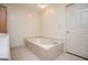 Bathroom featuring a large, tiled bathtub and a closed white door at 6026 Belle Meade Ct, Villa Rica, GA 30180