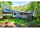 Backyard view of home with large deck and screened in porch, surrounded by lush landscape at 6026 Belle Meade Ct, Villa Rica, GA 30180
