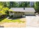 Traditional home featuring a cozy front porch and two-car garage, nestled within a wooded landscape at 6026 Belle Meade Ct, Villa Rica, GA 30180