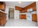 View of the kitchen showcasing wood cabinets and white appliances against neutral walls at 6026 Belle Meade Ct, Villa Rica, GA 30180