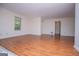 Living room featuring laminate floors, white walls, and natural light from the window at 6026 Belle Meade Ct, Villa Rica, GA 30180