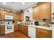 Kitchen featuring wood cabinets, white appliances and view to dining area at 3206 Abbott Dr # 12, Powder Springs, GA 30127