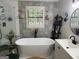 Modern bathroom featuring a freestanding tub, patterned wallpaper, and stylish fixtures at 4786 Carlene Sw Way # Iv, Lilburn, GA 30047