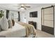 This is a stylish bedroom featuring a ceiling fan, television, and a sliding barn door at 4786 Carlene Sw Way # Iv, Lilburn, GA 30047