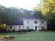 Traditional brick home featuring a manicured lawn, complemented by lush landscaping and mature trees at 4786 Carlene Sw Way # Iv, Lilburn, GA 30047