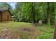 Picturesque backyard featuring lush trees, a fire pit, and a charming table set, ideal for outdoor relaxation at 6605 Old White Mill Rd, Fairburn, GA 30213
