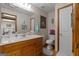 Bathroom with a single sink vanity, toilet, and framed art at 6605 Old White Mill Rd, Fairburn, GA 30213