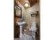 Quaint powder room features a pedestal sink, toilet, and decorative accents for guests' convenience at 6605 Old White Mill Rd, Fairburn, GA 30213