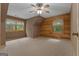 Bright, empty bedroom featuring warm wood walls and trim, complemented by natural light from multiple windows at 6605 Old White Mill Rd, Fairburn, GA 30213